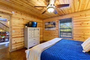 a bedroom with a bed and a ceiling fan at Wide Glide Lodge - In-home Movie Room, Hot Tub and Large 1-acre property with Playset in Broken Bow