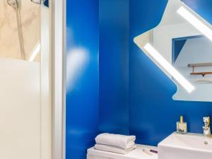 a blue bathroom with a sink and a mirror at IBIS BUDGET CAPAO Bonito in Capão Bonito +93 photos