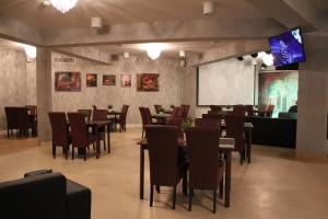 a restaurant with tables and chairs and a projection screen at Pokoje Gościnne WSAP in Ostrołęka