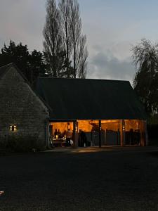 a house with a black roof with people inside at Ferme La Hougue B&B in Coigny +9 photos