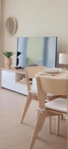 a living room with a table and a tv at Garden House 2 in São Vicente Ferreira