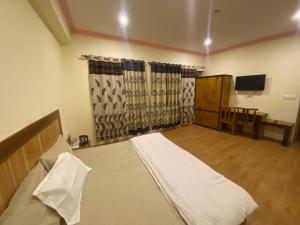 a bedroom with a bed and a television in it at Summer Villa in Leh