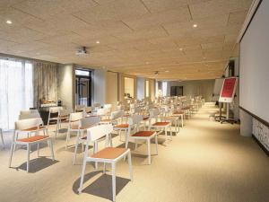 a classroom with white chairs and tables and a whiteboard at ibis Styles Montauban in Montauban +165 photos