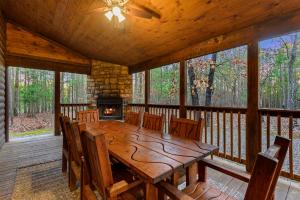 a wooden dining room with a table and a fireplace at Wide Glide Lodge - In-home Movie Room, Hot Tub and Large 1-acre property with Playset in Broken Bow