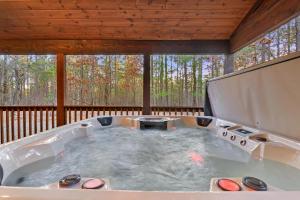a jacuzzi tub on a screened in porch at Wide Glide Lodge - In-home Movie Room, Hot Tub and Large 1-acre property with Playset in Broken Bow +106 photos