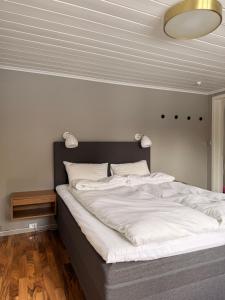a bedroom with a large bed with white sheets at Indreli feriehus in Flåm