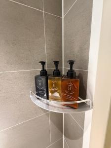 a shelf in a bathroom with three bottles on it at Regen Hotel in Seoul +5 photos