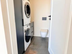 a small laundry room with a washer and dryer at Brúarárbyggð A2 in Blaskogabyggo