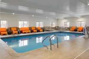 a large pool with orange chairs and a waiting room at EVEN Hotel Ann Arbor S - University Area by IHG in Ann Arbor