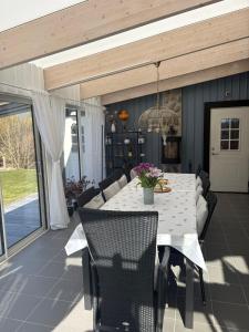 a dining room with a white table and chairs at Villa i sommaridyll 4 sovrum in Strömstad