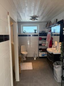 a bathroom with a sink and a toilet and a window at Villa i sommaridyll 4 sovrum in Strömstad +15 photos