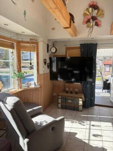 a living room with a couch and a flat screen tv at Villa i sommaridyll 4 sovrum in Strömstad