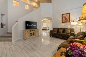 a living room with a flat screen tv on a cabinet at Pool Grill Games Chill - Surprise Awaits in Surprise