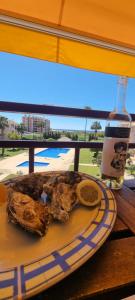 a plate of food and a bottle of drink on a table at Dunas de vilamoura in Quarteira