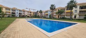 a swimming pool in front of some apartment buildings at Dunas de vilamoura in Quarteira