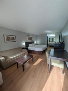 a hotel room with a bed and a couch at Garden Inn Adairsville in Adairsville