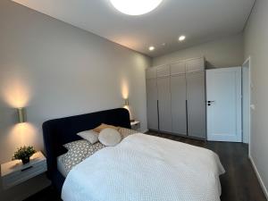 a bedroom with a white bed and a white cabinet at Brúarárbyggð A2 in Blaskogabyggo +25 photos