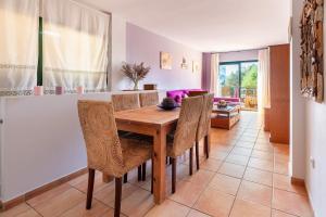 a dining room with a wooden table and chairs at Apartamento Ca Na Fina, tranquilo y cerca de la playa de Es Pujols in Es Pujols