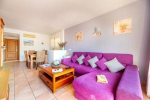 a living room with a purple couch and a table at Apartamento Ca Na Fina, tranquilo y cerca de la playa de Es Pujols in Es Pujols