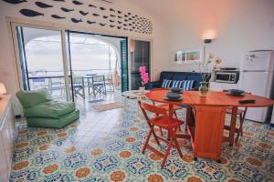 a kitchen and a living room with a table and chairs at Villetta La Conca in Conca dei Marini