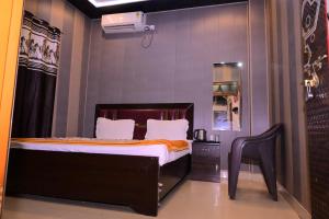 a bedroom with a bed and a chair in it at Swastik homestay ayodhya in Ayodhya