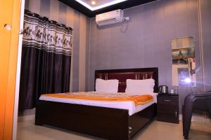 a small bedroom with a bed with an orange blanket at Swastik homestay ayodhya in Ayodhya