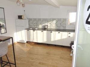 a kitchen with white cabinets and a wooden floor at Premont Studios Ghimbav in Ghimbav +67 photos