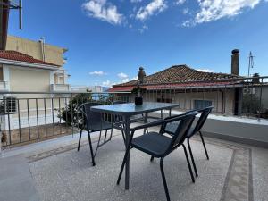a table and chairs on a patio with a house at Sea & Stone House in Nafpaktos
