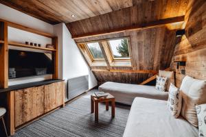 a living room with a couch and a tv at Alliey & Spa Piscine Appart-hôtel Serre chevalier in Le Monêtier-les-Bains