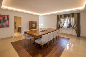 a dining room with a wooden table and chairs at Villa Buganvilia III in Aroeira