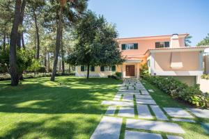 a garden with a pathway leading to a house at Villa Buganvilia III in Aroeira