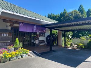 a building with a bench and flowers in front of it at 霧島花紫 in Kirishima
