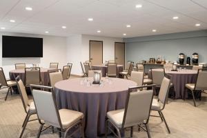 a conference room with tables and chairs and a screen at EVEN Hotel Ann Arbor S - University Area by IHG in Ann Arbor +53 photos