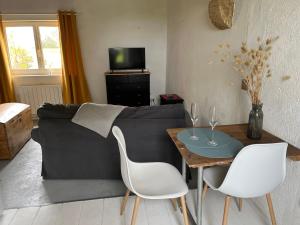 a living room with a couch and a table and chairs at Le refuge in Marsalès