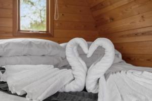 a bed with two swans made to look like hearts at Lakeside Nest - Fishing Lakes, Heated Outdoor Swimming Pool 500yrds on Sister Park , Pool Open May to September in Exeter
