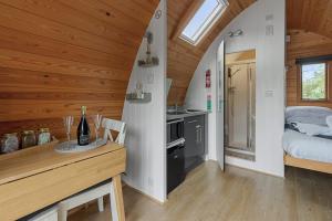 a kitchen and bedroom in a log cabin with a bed at Lakeside Nest - Fishing Lakes, Heated Outdoor Swimming Pool 500yrds on Sister Park , Pool Open May to September in Exeter