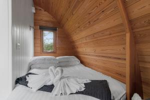 a bed in a room with a wooden ceiling at Lakeside Nest - Fishing Lakes, Heated Outdoor Swimming Pool 500yrds on Sister Park , Pool Open May to September in Exeter