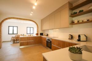 a kitchen with wooden cabinets and a table in it at Villa Phi Phi - com piscina privada em Vilamoura in Quarteira