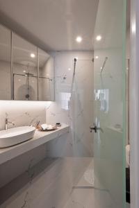a white bathroom with a sink and a shower at Downtown Skyloft in Kalamata +46 photos