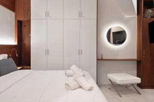 a bedroom with a white bed and a mirror at Downtown Skyloft in Kalamata