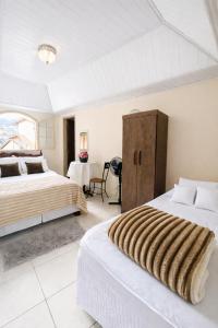 a bedroom with two beds and a table at Vila Rica Hospedaria in Ouro Preto
