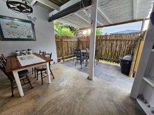 a patio with a table and chairs and a fence at Heide Cottage in Struisbaai