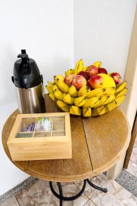 a bowl of fruit on a table with a bowl of bananas at Vila Rica Hospedaria in Ouro Preto