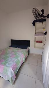 a bedroom with a bed and a clothes rack at Quartos Viracopos independente in Campinas