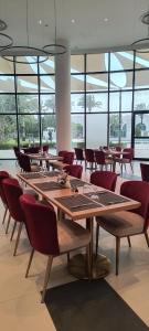 a dining room with tables and chairs and windows at Arabian Palace Hotel in Al Rahba