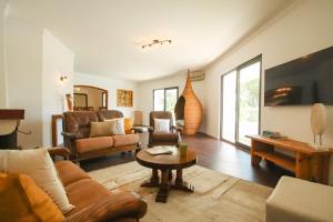 a living room with a couch and a table at Villa Phi Phi - com piscina privada em Vilamoura in Quarteira