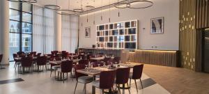 a restaurant with tables and chairs in a room with windows at Arabian Palace Hotel in Al Rahba