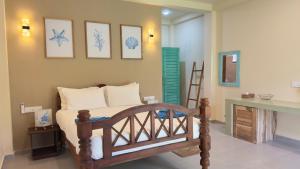 a bedroom with a bed and some pictures on the wall at Thambapanni Villa in Unawatuna