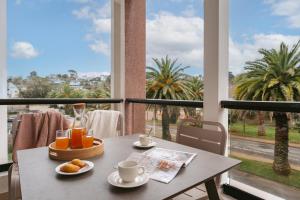 a table with a tray of food on a balcony at Résidence Pierre & Vacances L'Archipel in Perros-Guirec