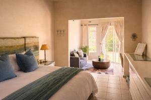 a bedroom with a bed and a living room at Midrand Manor Guesthouse in Midrand +35 photos